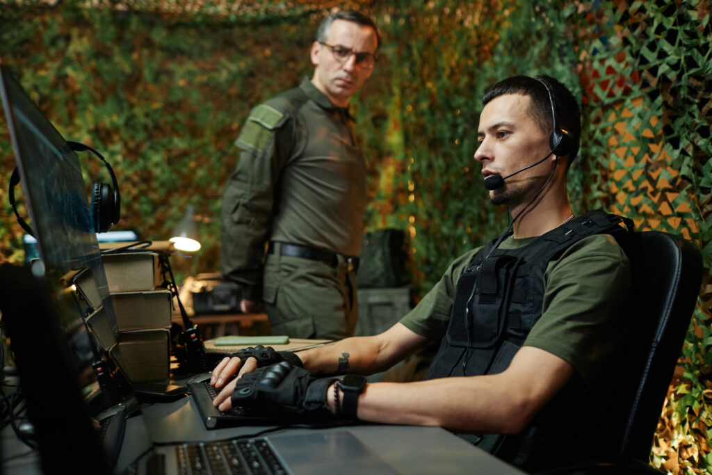 Image of the Command Edge in defense, depicting an operator on a computer analyzing refined Operational data, supervised by an officer in a federal command hub.