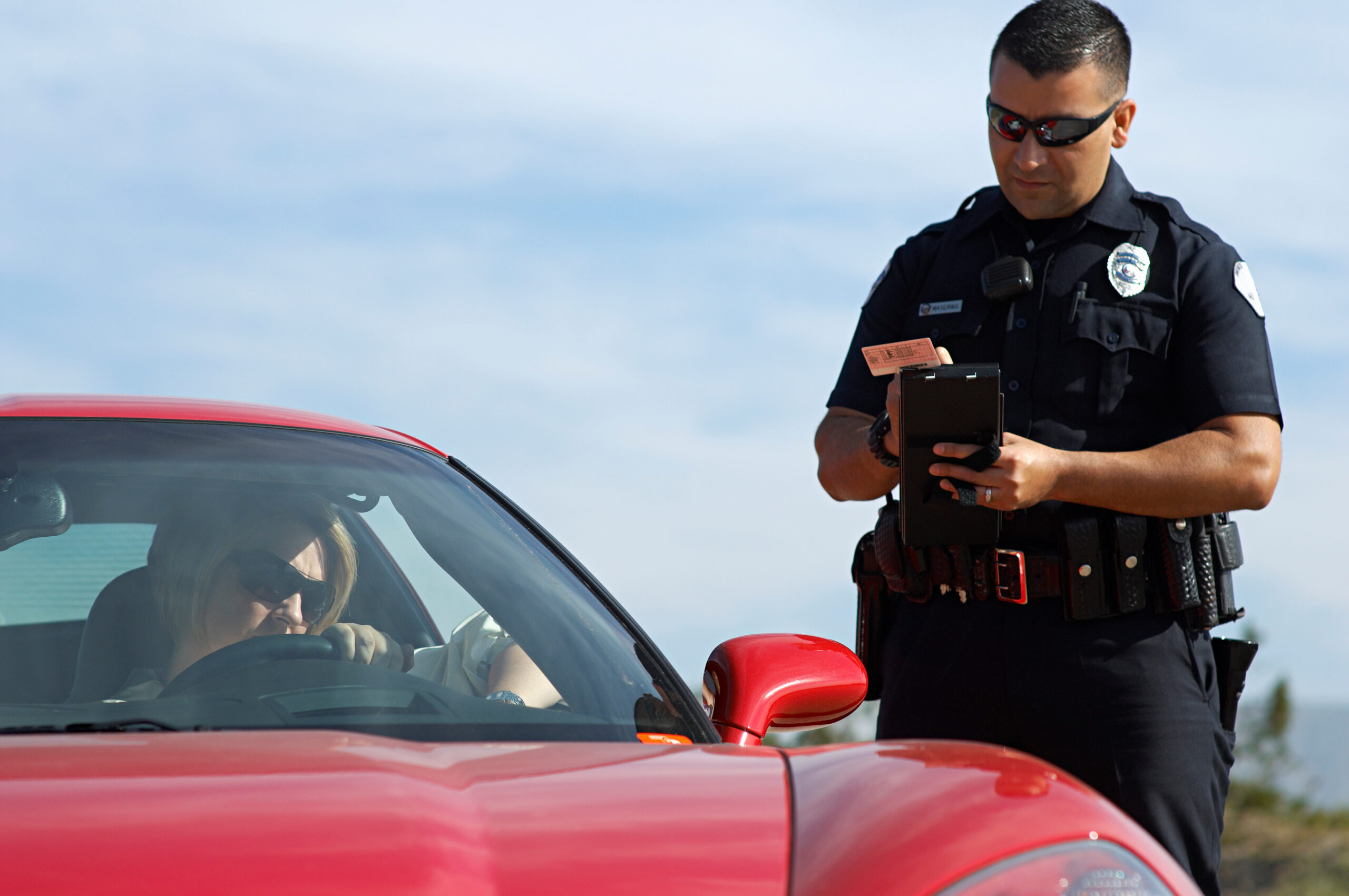 Law enforcement using a wearable AI translator device for real-time language translation during traffic stops and field interactions.
